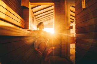 Ilustrace A young woman relaxing in an eco wooden sauna, Yana Iskayeva,