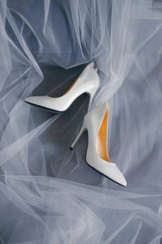 Umělecká fotografie Bride's shoes with a veil top view close-up, Artem Sokolov,