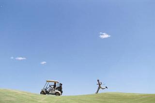 Umělecká fotografie Golfer Chasing Golf Cart, Sean Justice,