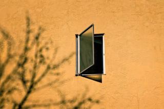 Umělecká fotografie Open window on a orange wall, Thomas Winz,