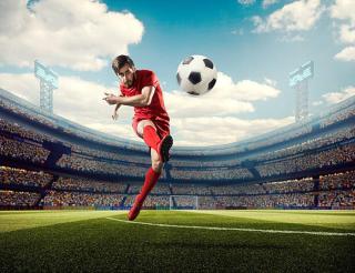 Umělecká fotografie Soccer player kicking ball in stadium, Dmytro Aksonov,